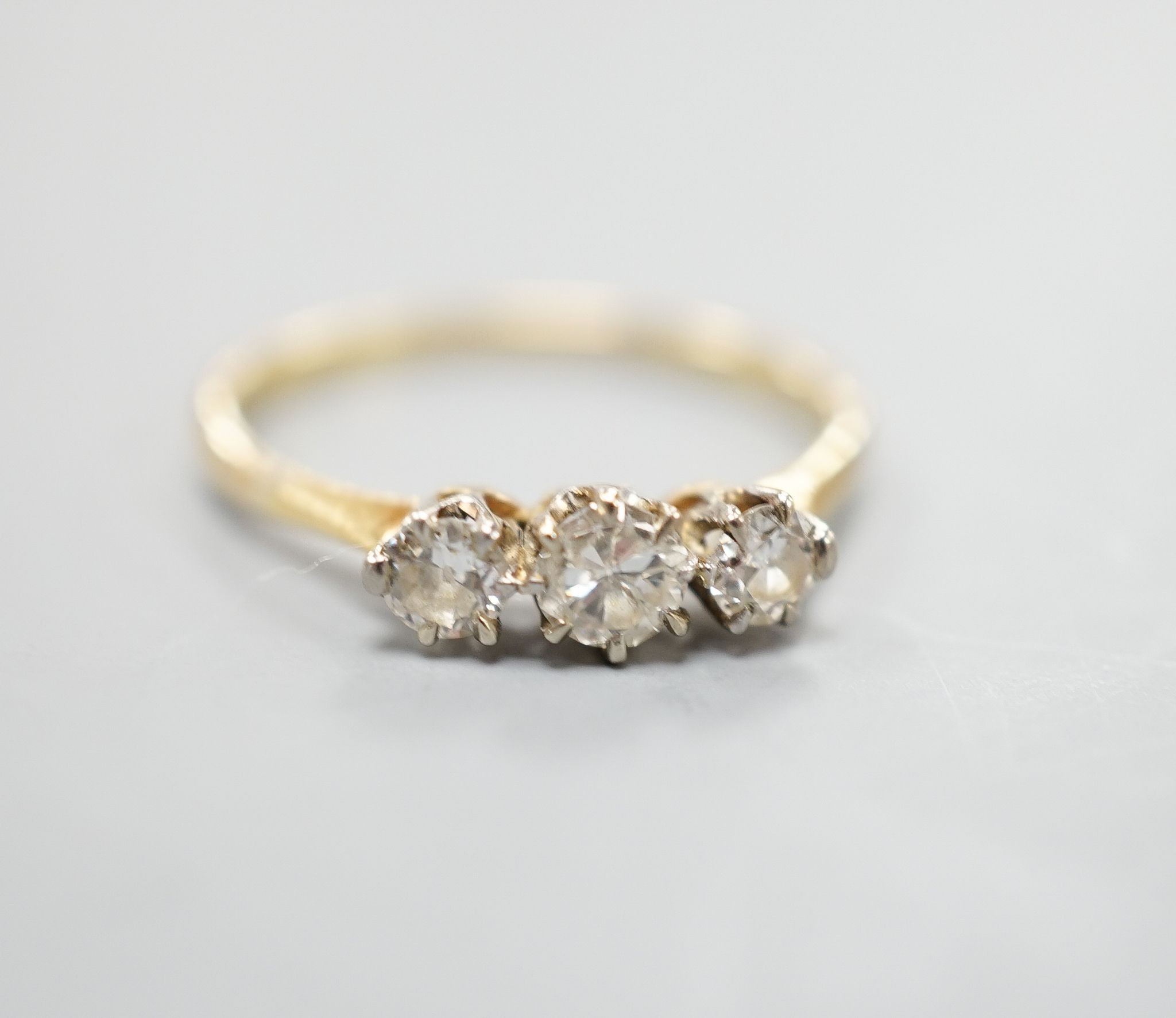 An 18ct and three stone diamond set ring, size P/Q, gross weight 1.7 grams.